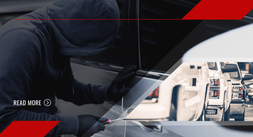 Hooded thief attempting to break into a car at night, representing vehicle theft risks and the importance of GPS tracking for stolen vehicle recovery.