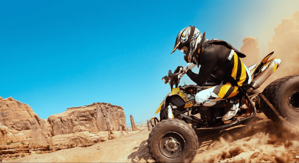 Person riding an ATV in the desert, representing GPS tracking for all-terrain vehicles and off-road fleet management.