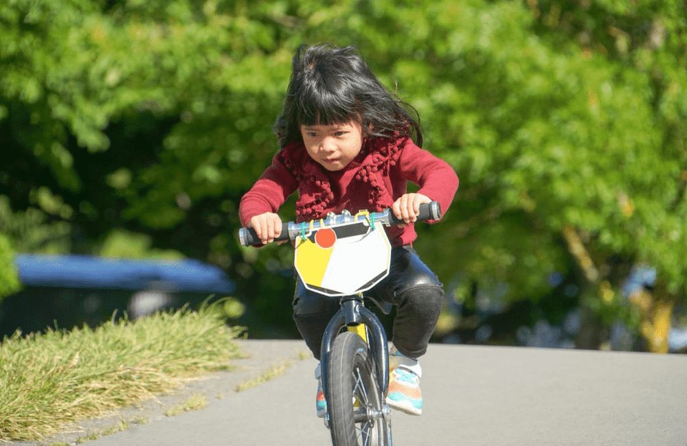Young child riding a bicycle outdoors, representing the best GPS tracker for kids to ensure safety and peace of mind for parents.