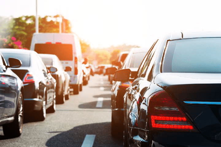 Cars and vans stuck in traffic on a busy road, representing GPS car tracking and fleet management solutions for businesses.