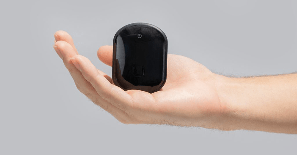 Compact black GPS tracker resting in a person’s hand, representing portable GPS tracking device for cars, assets, and personal safety.