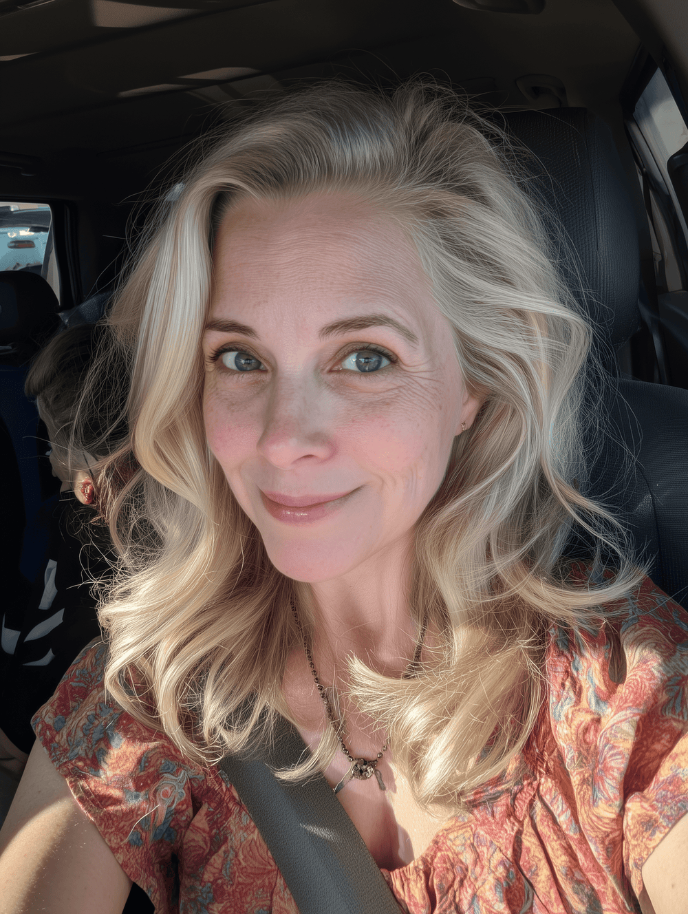 Woman with blonde hair sitting inside a vehicle