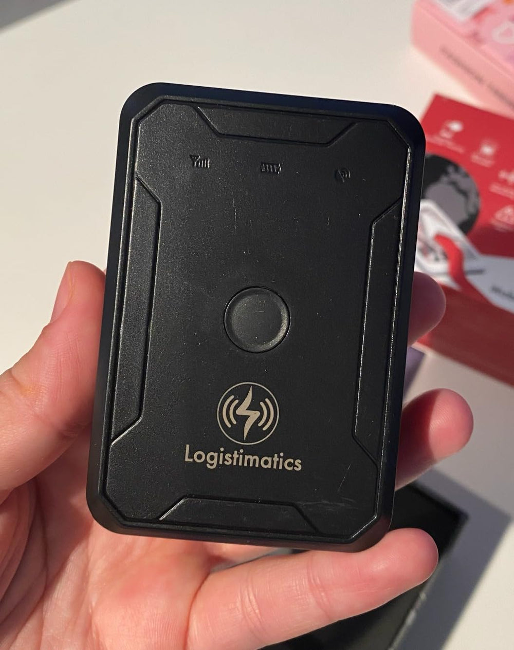 GPS device holding in hand with box in the background.