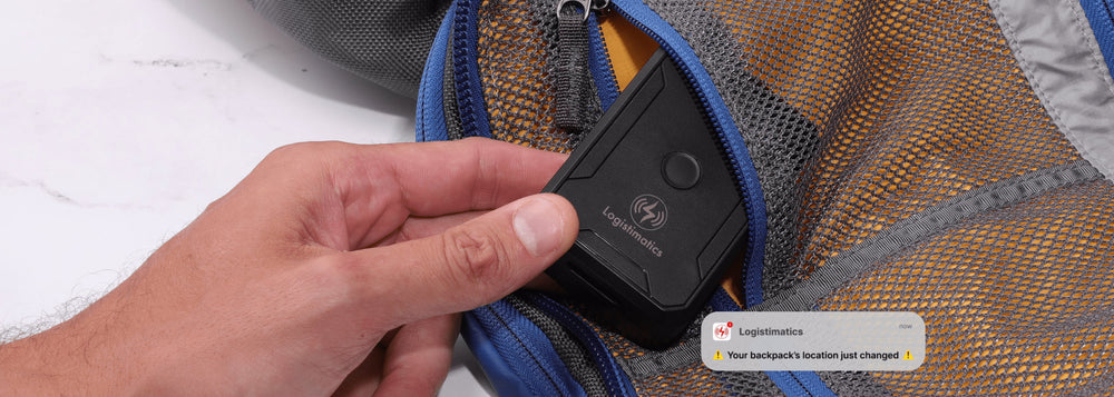 Hand placing GPS tracking device into backpack pocket with smartphone alert showing location change notification.