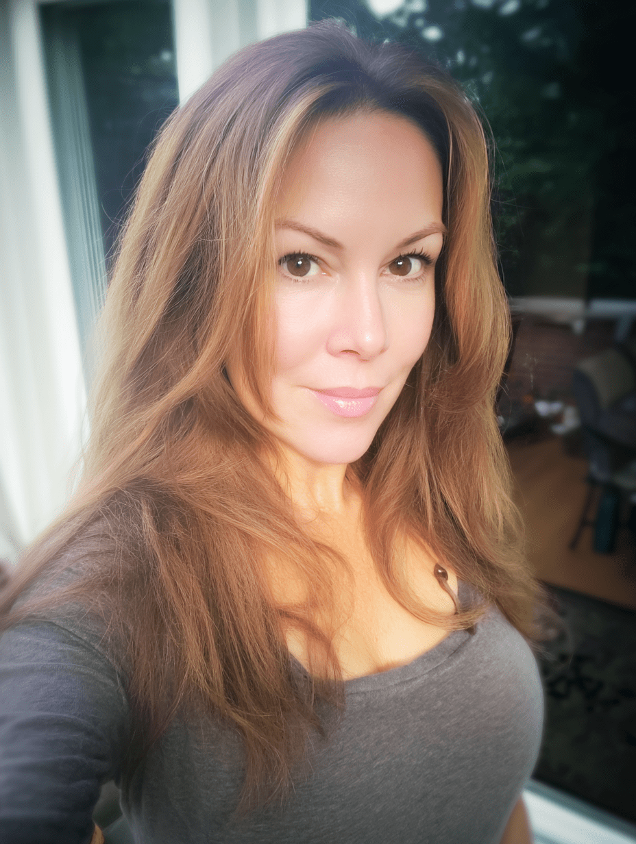 Woman with long brown hair taking a selfie indoors