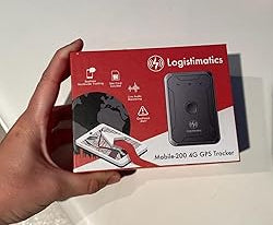Hand holding a red and black Logistimatics GPS device packaging with visible branding.