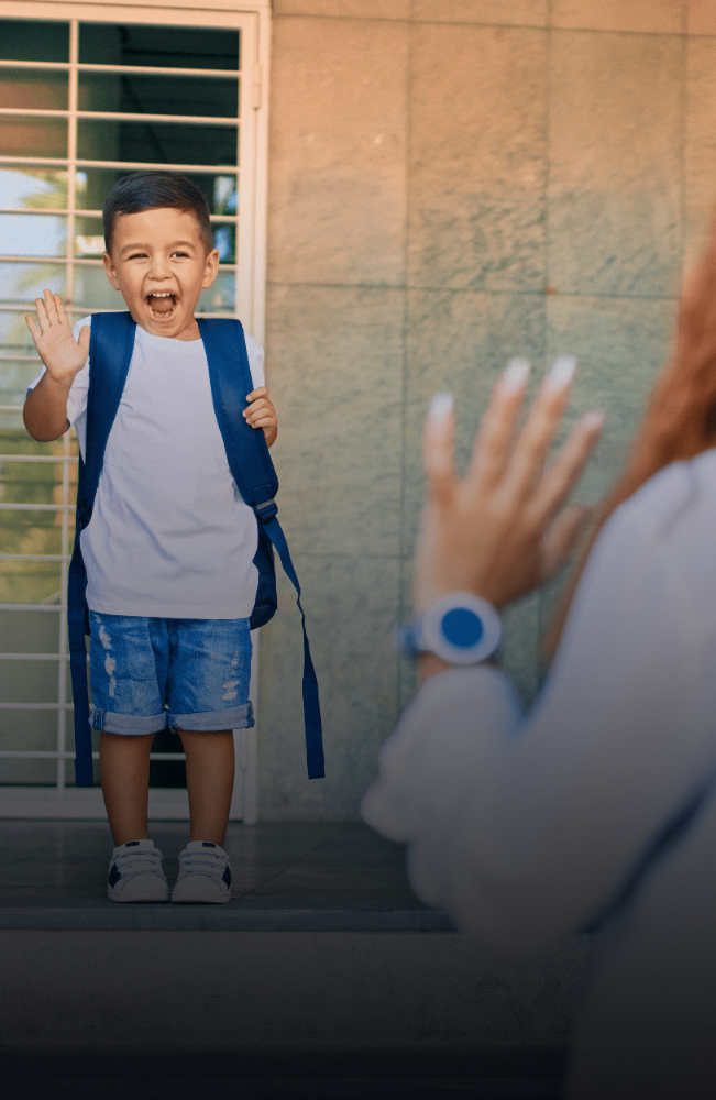 Excited child with backpack waving goodbye to parent wearing GPS smartwatch, highlighting family safety and child tracking.