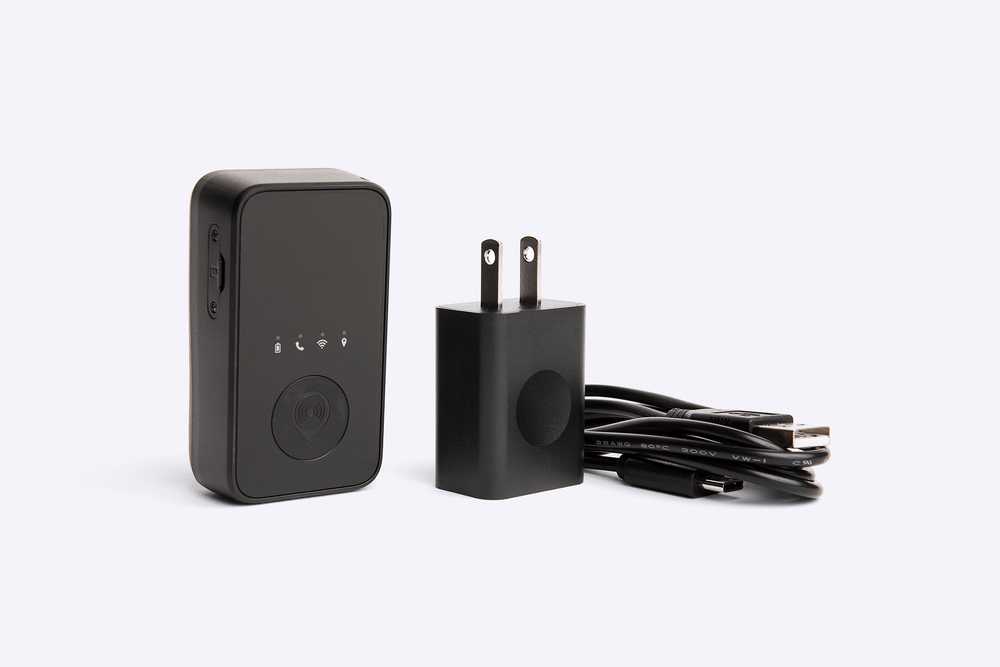 Black GPS device with wall adapter and cable on a white background
