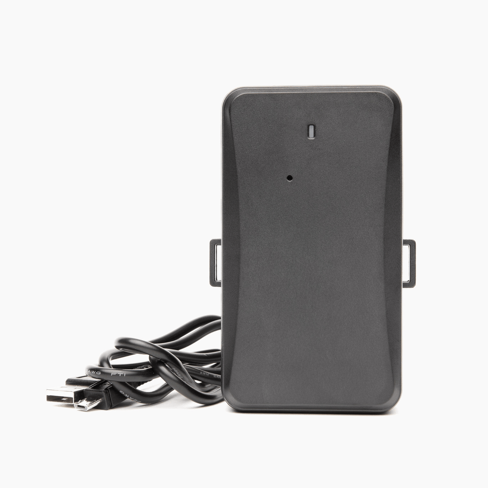 Black GPS tracker device with USB charging cable for real-time vehicle and asset tracking, isolated on white background.