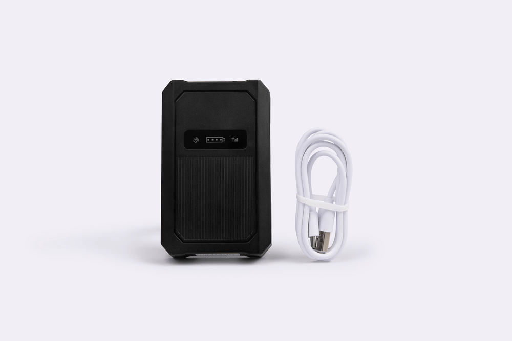 Small black GPS tracker and charging cable.