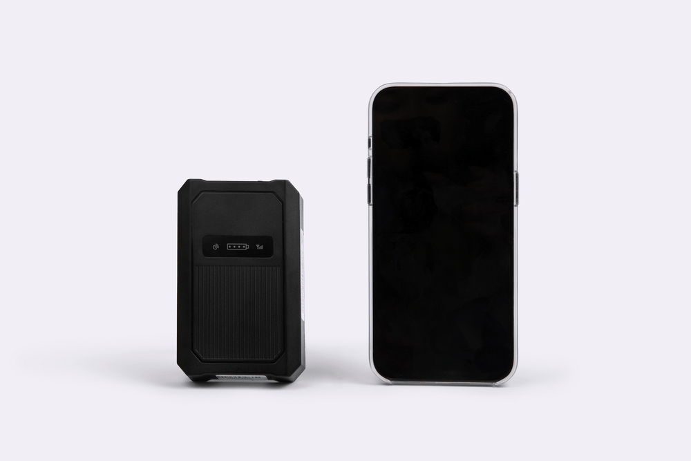 Black gps tracker case and smartphone on a white background