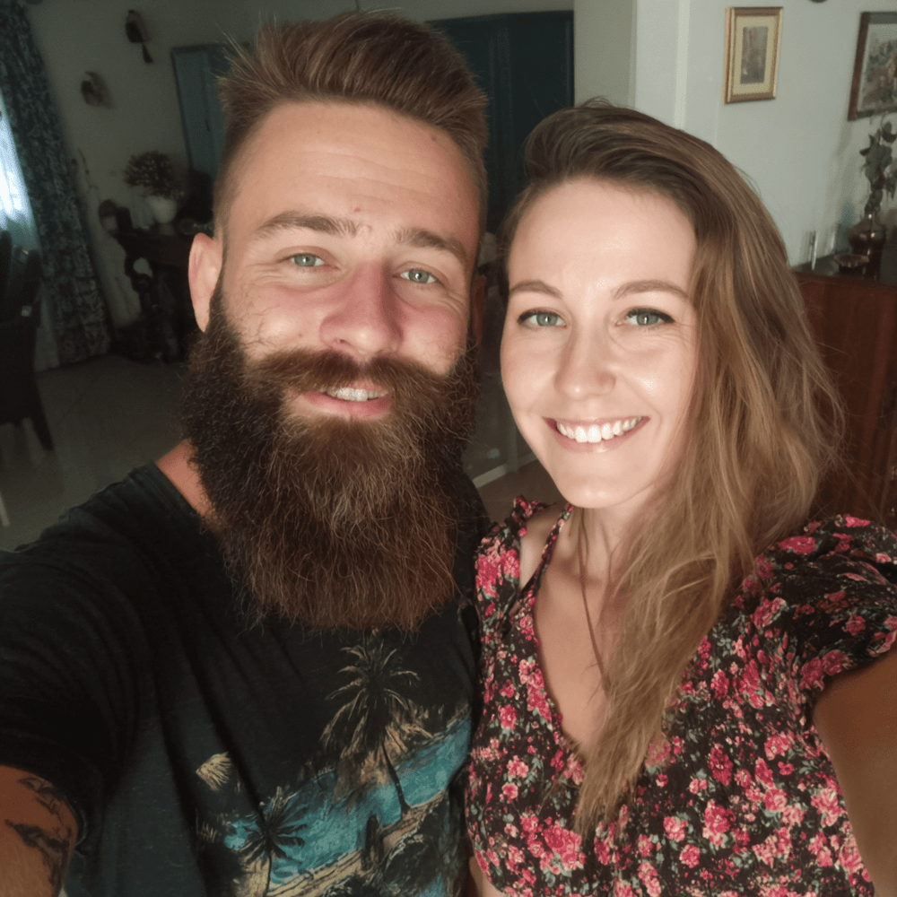 Man with a beard and woman smiling indoors