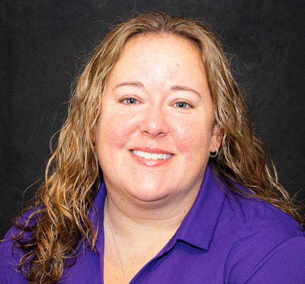 Woman wearing a purple shirt with a logo on a black background