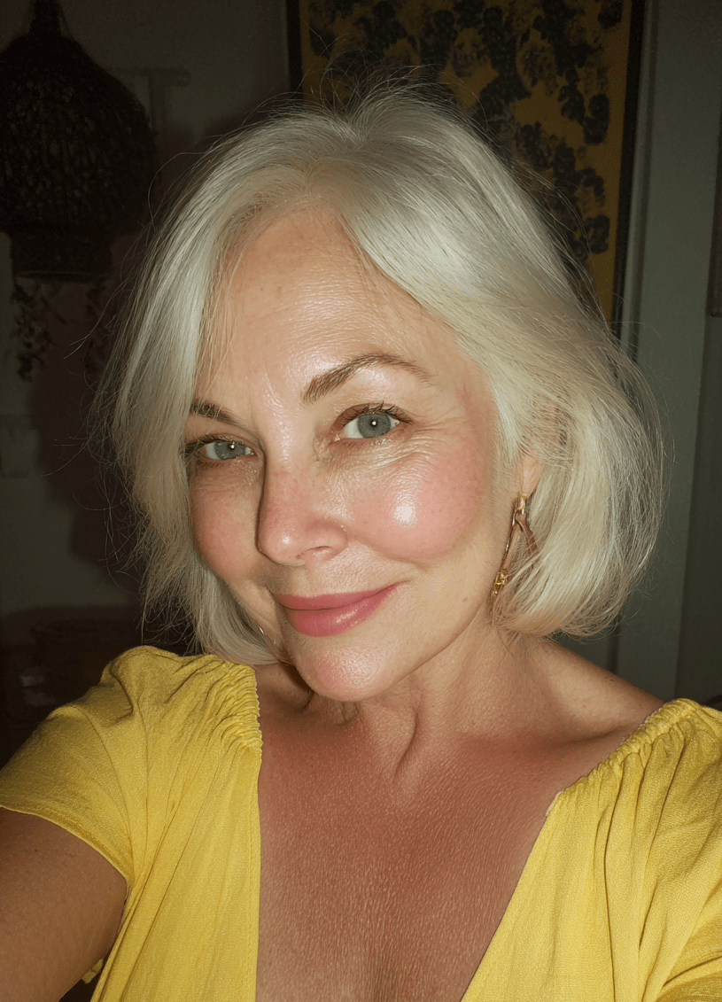 Woman with blonde hair wearing a yellow top indoors